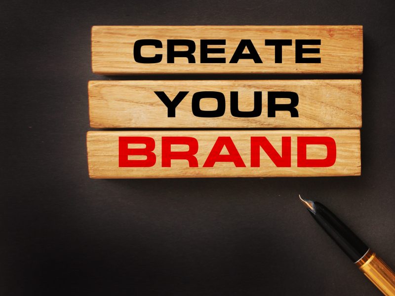 BUILD YOUR BRAND words on Wooden Blocks and luxury pen on blcack. Business Strategy and Marketing Concept.